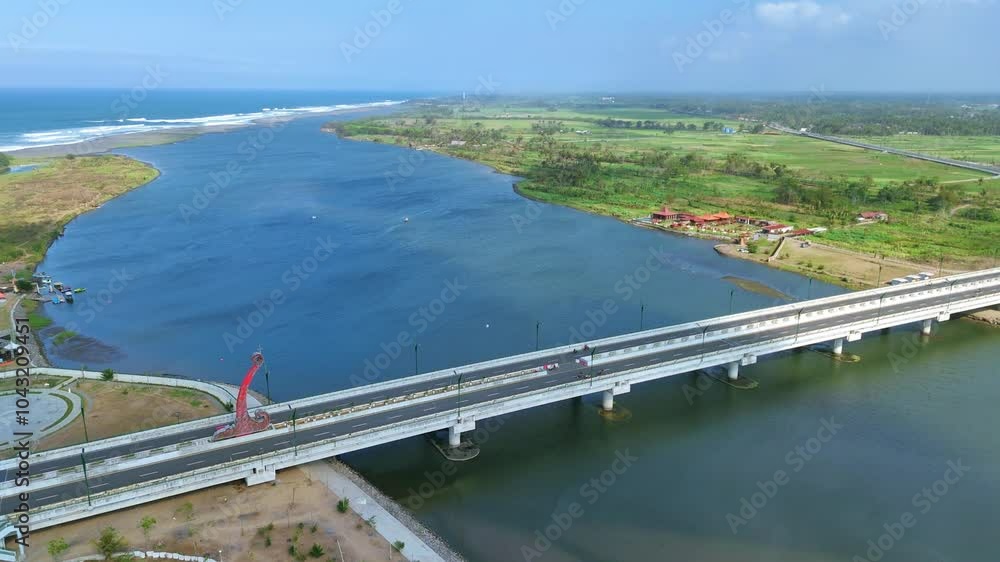 Aerial view of large bridge on the wide river and coastline on the background. Kretek II Bridge, Depok Beach, Yogyakarta, Indonesia. 4K drone footage. Aerial view of large bridge on the wide river and coastline on the background. Kretek II Bridge, Depok Beach, Yogyakarta, Indonesia. 4K drone footage.