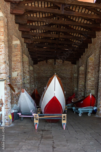 VENICE, ITALY - APRIL 11 2023: A unique view of a gondola storage and repair workshop, alongside a boat garage and dry dock.