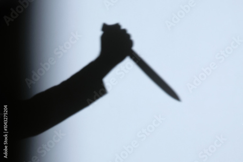Photography Male hand shadow holding with kitchen knife on the wall in home to night