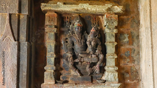 Carved sculptures of Lord Shiva with Goddess Parvati in the antarala of Kumbheshwara Mahadev Temple, Arthuna Group of Temples, Banswara, Rajasthan, India. photo