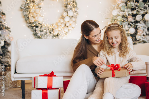 Fotografie Mother and Daughter Enjoying Christmas Gift Opening Together