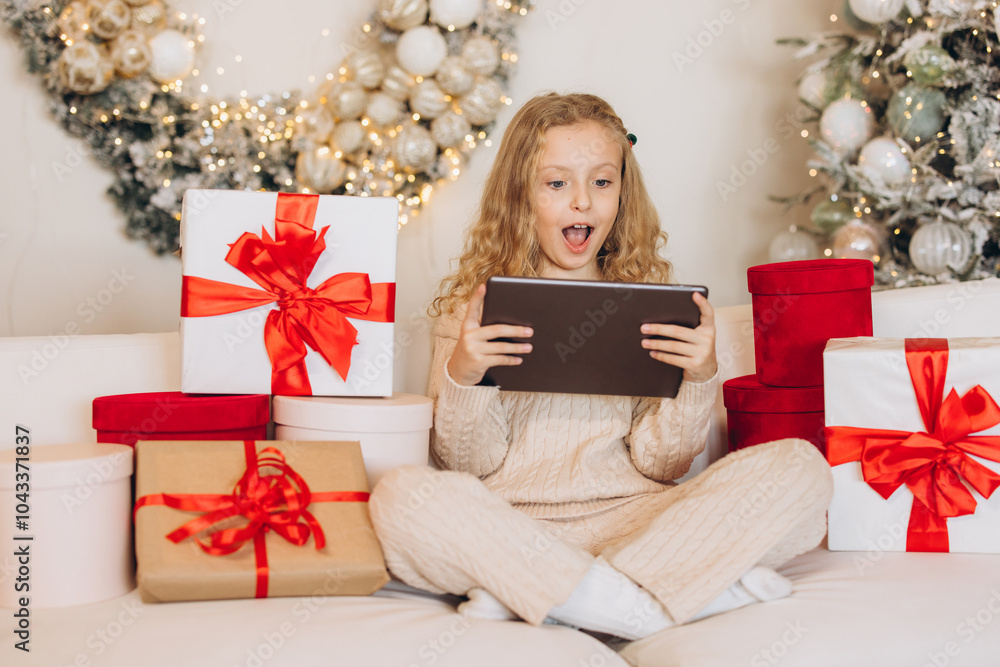 Excited Little Girl With Tablet Among Christmas Gifts and Decorations