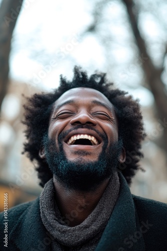 A smiling man with a beard and scarf, showing joy