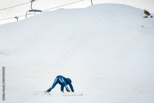 Beginner amateur skier learn to ski fall looking funny on snowy slope in ski resort. Wear jeans wrong apparel ski gear. Skier unprepared learning skiing alone with no instructor making fun of himself