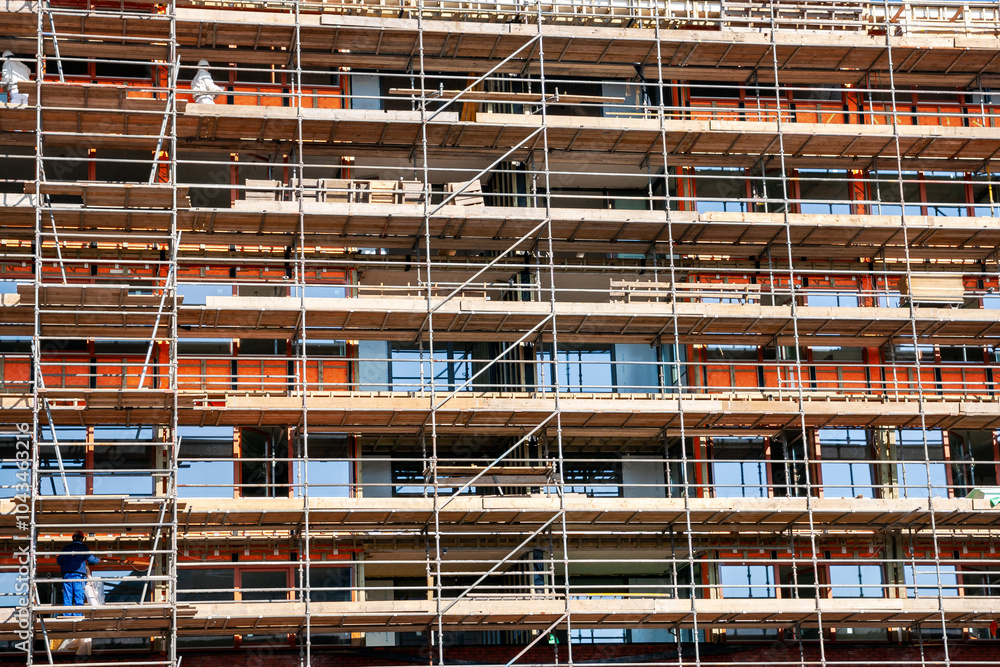 Scaffolding against a new apartment building on a construction site. Scaffolding against a new apartment building on a construction site.