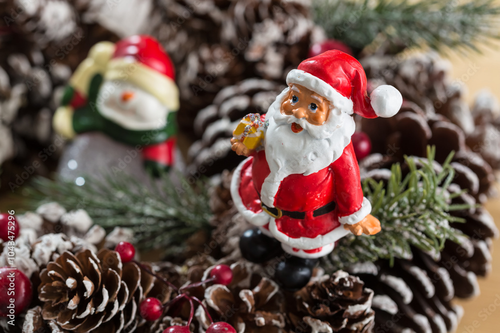 Obraz premium A small figurine of Santa Claus in a red and white suit holding a green sack,