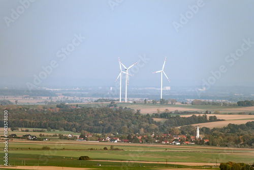 Panoramic view of three wind Turbines in a Scenic Rural Landscape on a foggy day, showcasing renewable energy and environmental sustainability photo