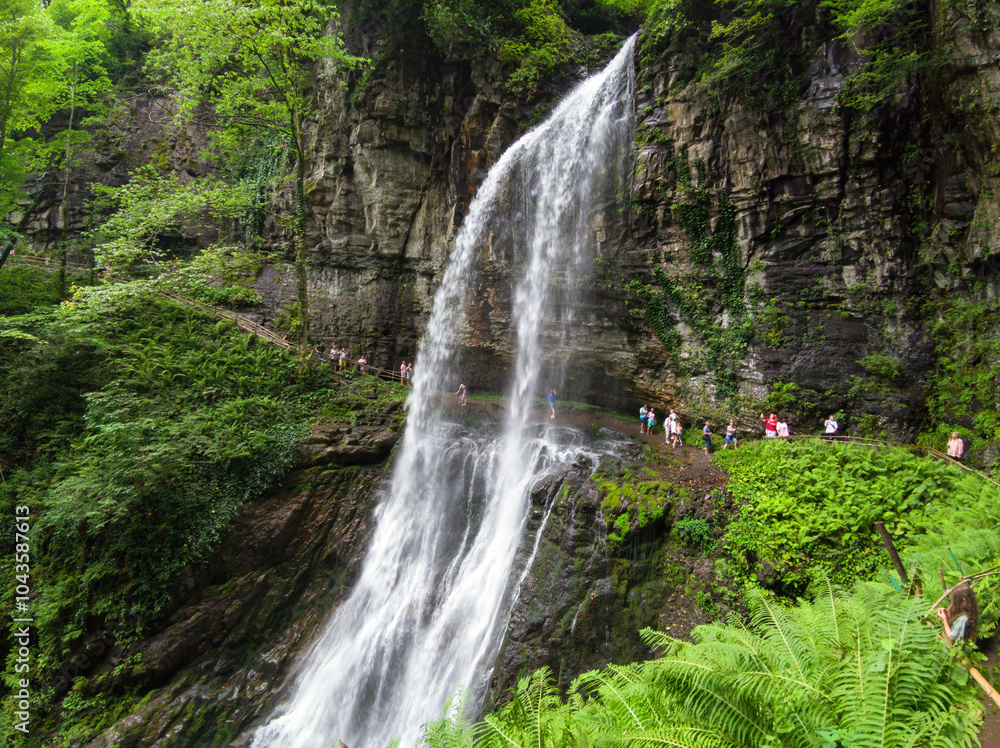 Waterfall the Giant or Velikan in Abkhazia, great spring in mountain in summer. Concept of forest, water, nature, landscape, travel Waterfall the Giant or Velikan in Abkhazia, great spring in mountain in summer. Concept of forest, water, nature, landscape, travel