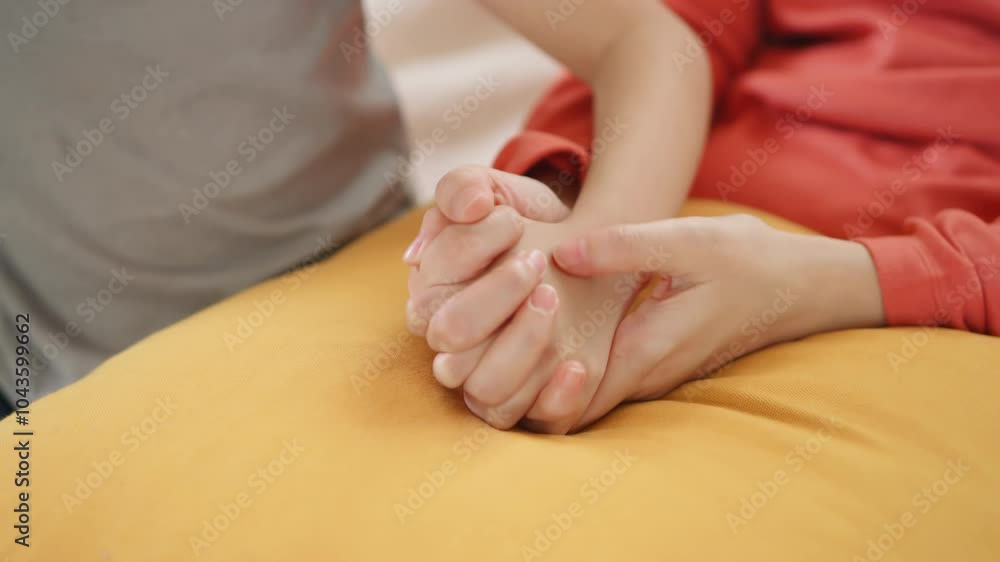 Mother and daughter holding hands in a close, supportive moment. Mother and daughter holding hands in a close, supportive moment.