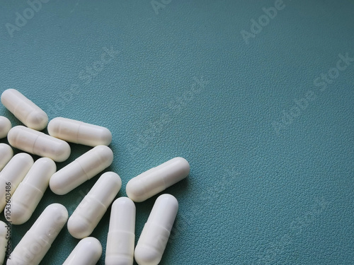 White medical pills on green background with space