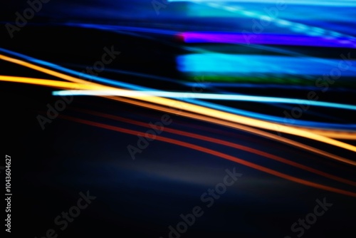 A blurred image of a car with a blue and orange stripe. The car is in motion, creating a sense of speed and energy. The blue and orange colors contrast with the dark background