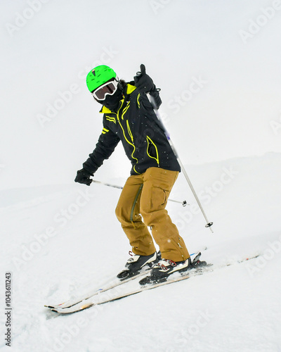 Alpine ski. Front side view skiing male skier going downhill show thumbs up on snow covered isolated white ski trail slope piste in winter. Good recreational male skier