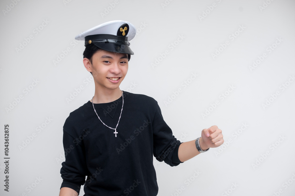 A jolly young asian man wearing a captain's hat jiving. Isolated on a white background. Nautical cruise ship themed event. A jolly young asian man wearing a captain's hat jiving. Isolated on a white background. Nautical cruise ship themed event.