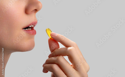 Woman takes omega-3 fish oil capsules orally. Showcasing vitamins, dietary supplements, and nutrition products. Intake of healthy fats, omega-3 fish oil.