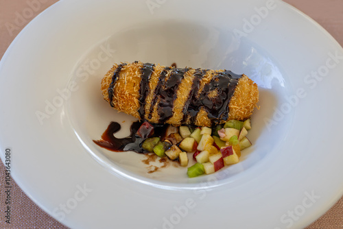 Fried ice cream with shredded wheat, fruit pieces and chocolate sauce on a white porcelain plate (Hot ice cream) photo