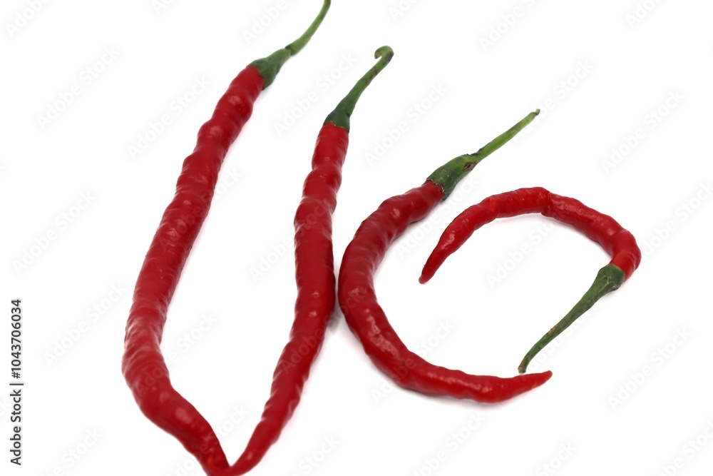 A bunch of red chili peppers are arranged on a white background. The chilies are long and slender, with a glossy appearance. They are slightly curved and have a green stem. A bunch of red chili peppers are arranged on a white background. The chilies are long and slender, with a glossy appearance. They are slightly curved and have a green stem.