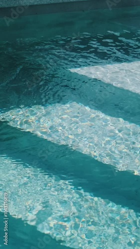 Steps in the pool with blue ceramic tile mosaic. Relax in the backyard of a country house
