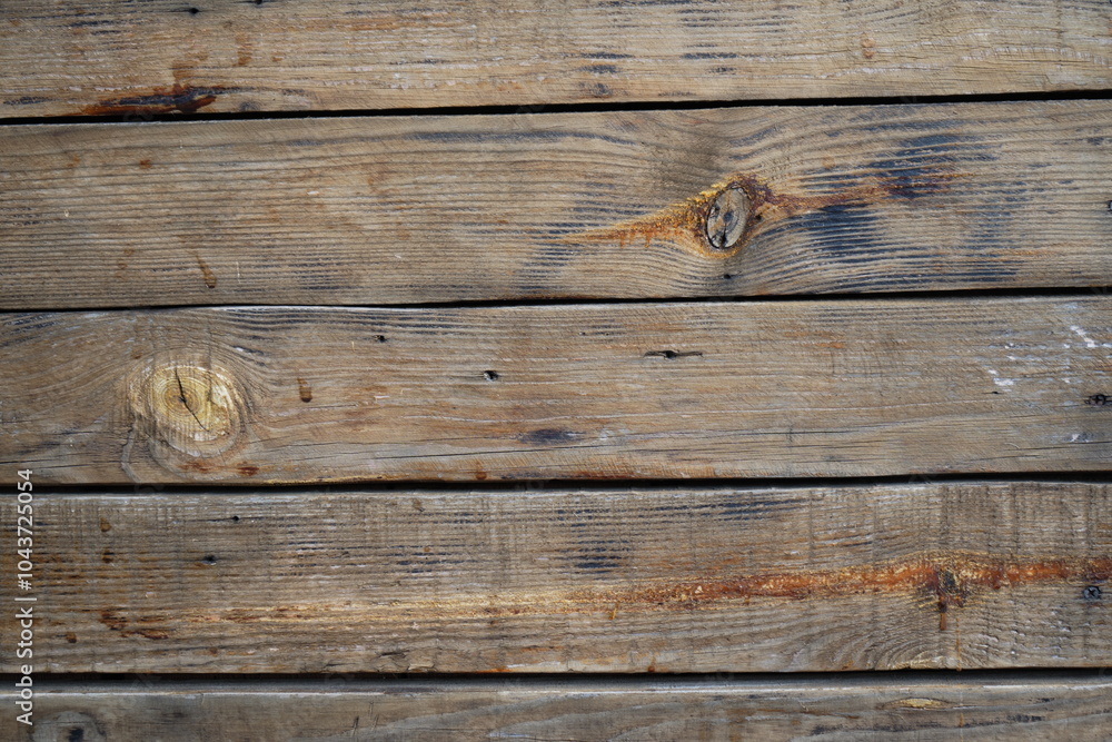 This image shows weathered wooden planks with distinct grain patterns, knots, and natural discoloration. The aged texture highlights the effects of time and elements on wood This image shows weathered wooden planks with distinct grain patterns, knots, and natural discoloration. The aged texture highlights the effects of time and elements on wood