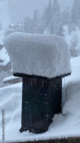 A mailbox that is completely covered in snow is sitting on the ground photo