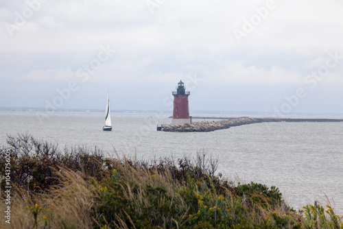 Delaware Breakwater Lighthouse and Small Sailboat photo