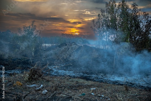 Smoke and sunset against the backdrop of a burning landfill: an ecological disaster