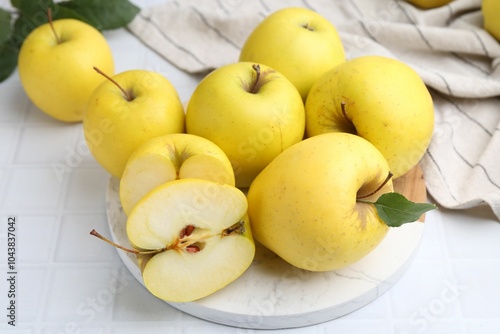 Fresh ripe yellow apples on white tiled table photo