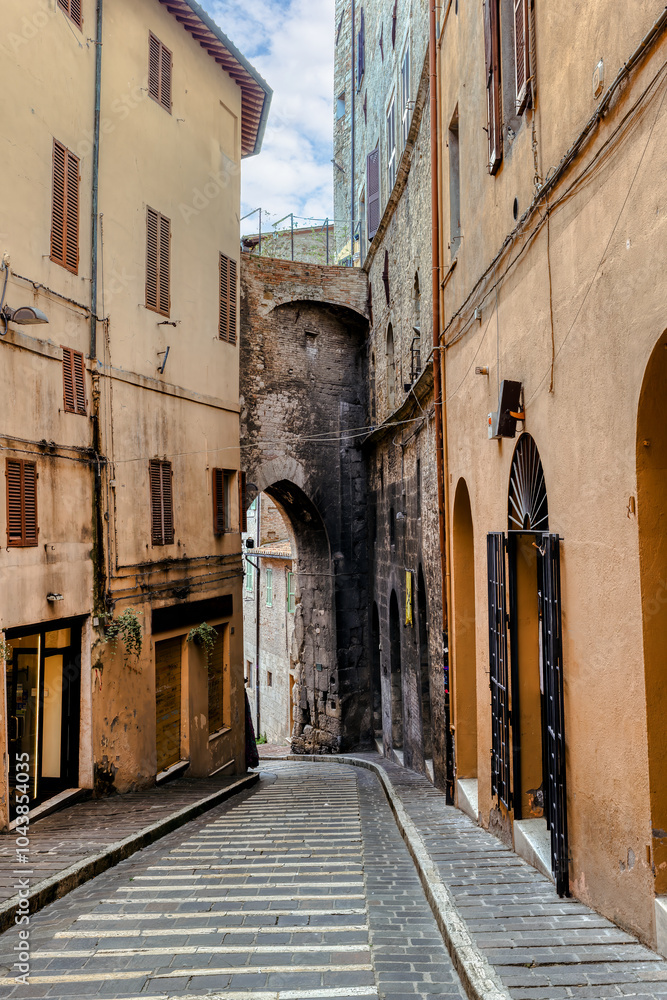 The narrow, cobblestone streets of Perugia, where ancient stone buildings and arches create a captivating atmosphere steeped in history. Perugia, Umbria, Italy.