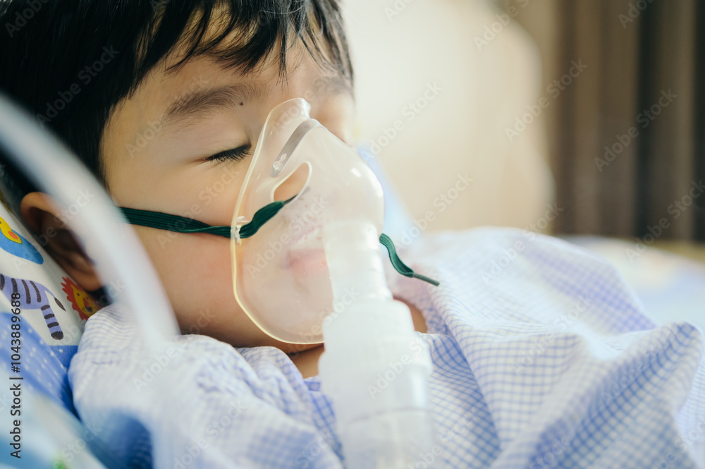 Boy 4 years old , inhale medication by inhalation mask to cure Respiratory Syncytial Virus (RSV) on hospital bed. Admitted patient boy inhalation therapy.