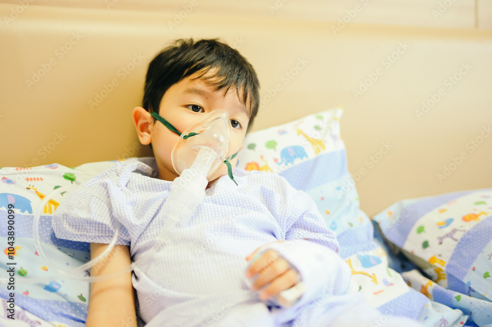 Boy 4 years old , inhale medication by inhalation mask to cure Respiratory Syncytial Virus (RSV) on hospital bed. Admitted patient boy inhalation therapy.