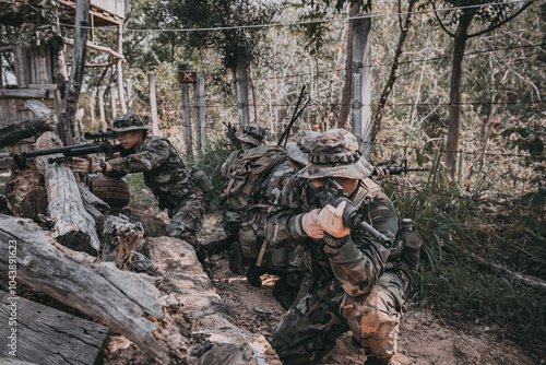 фотографія Team of army soldier with machine gun moving in the forest,Thai militia soldier in combat uniforms in the wood,Wander the patrol sloping in the rainforest