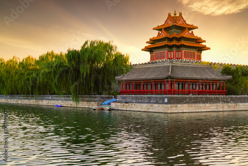 View of the Forbidden City with the reflection on the moat at sunset in Beijing, China. photo