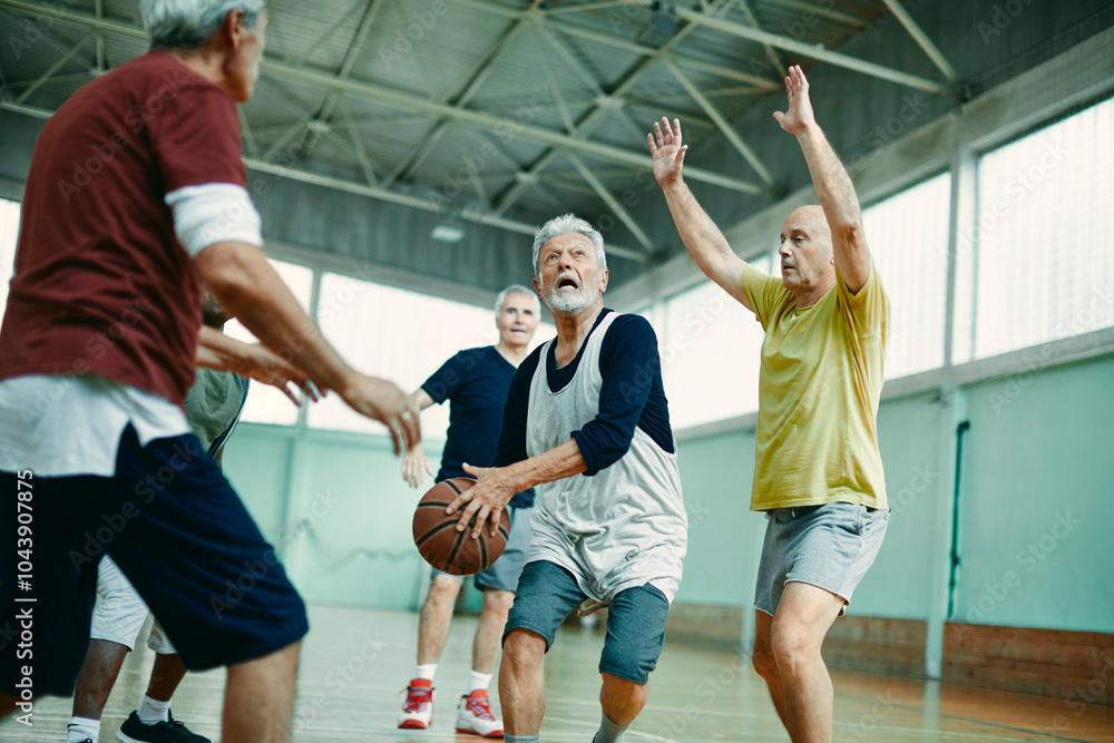 Obraz premium Seniors playing basketball in an indoor gym