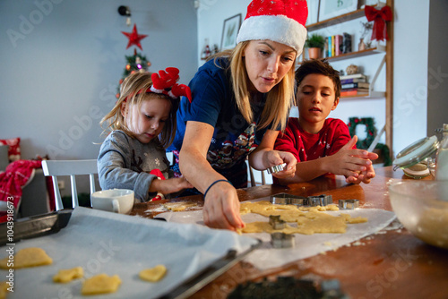 Family baking Christmas cookies together in festive kitchen photo