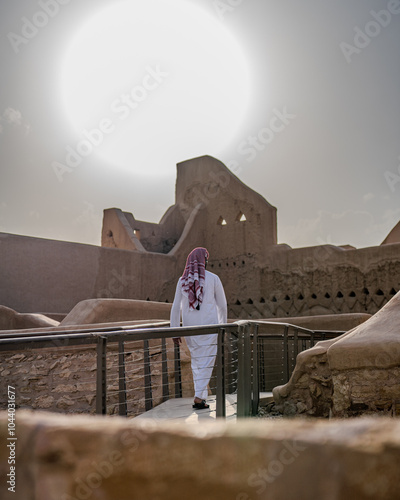 Man wearing thawb and keffiyeh walking in At-Turaif World Heritage Site
