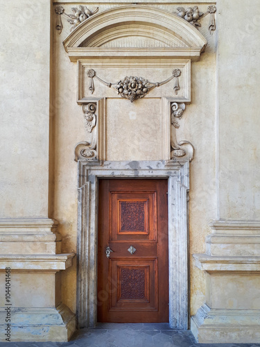 Ornate wooden door set in an intricately designed stone doorway, showcasing classical architectural elements.