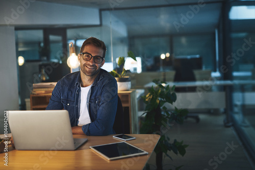 Night, portrait and man in office with laptop, confidence and business planning at digital agency. Smile, dark and creative tech consultant with computer, web design and online research at desk