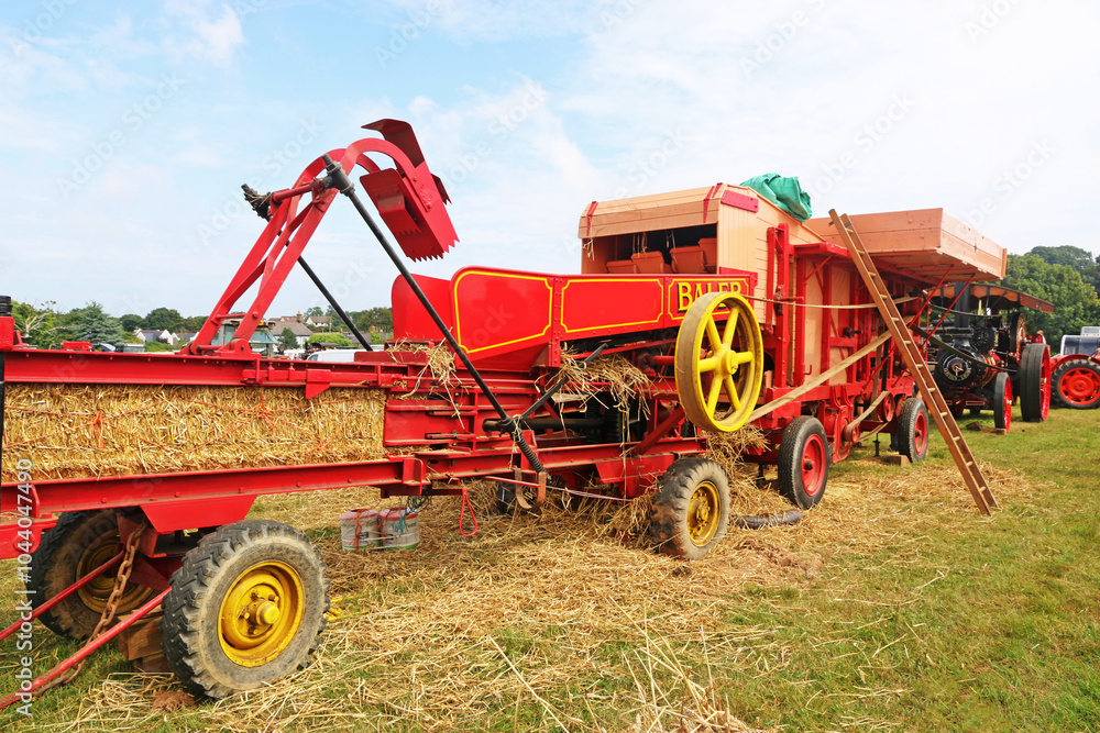 Fototapeta premium Vintage baler working in a field