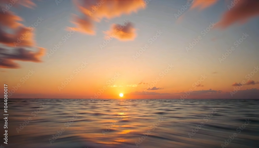 Obraz premium A beautiful sunset over the ocean, with the sun reflecting on the calm water. The sky is filled with warm, vibrant colors of orange and red, creating a serene and peaceful atmosphere