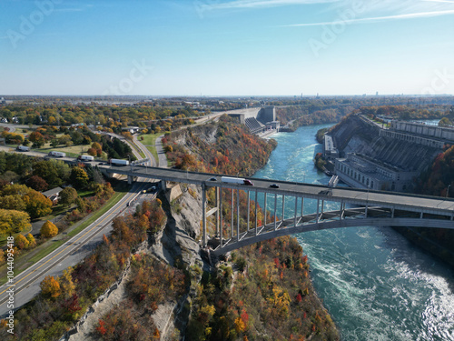 Aerial over the Niagara River and gorge, the international border crossing Queenston-Lewiston bridge between New York, United States and Ontario, Canada with hydroelectrical power plants, in autumn.