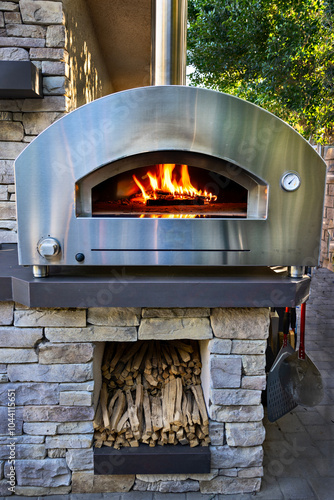 A stainless steel woodfried home pizza oven with fire inside photo