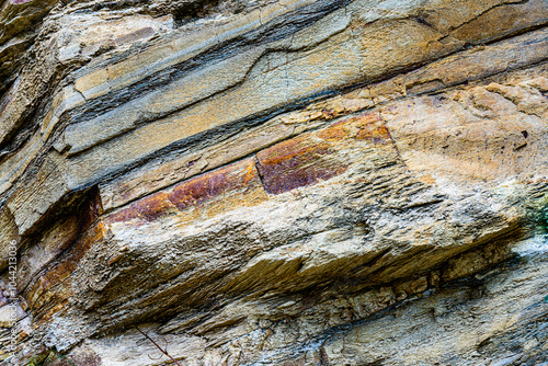 Nature force compressed cracked rock layers structure formation close-up details, in various shapes, colors, thicknesses, at north central coast of Crete, Greece. Nature and Geological science concept photo