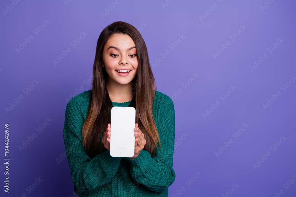 Portrait of pretty young girl show empty space phone screen wear sweater isolated on violet color background Portrait of pretty young girl show empty space phone screen wear sweater isolated on violet color background