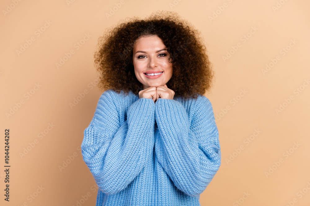 Portrait photo of cute young stunning girl wearing blue knitted sweater touch chin smiling isolated on beige color background Portrait photo of cute young stunning girl wearing blue knitted sweater touch chin smiling isolated on beige color background