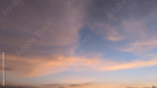 A beautiful sunset sky with shades of pink, purple, and orange. The clouds are wispy and form interesting patterns. The horizon is barely visible, blending into the sky.