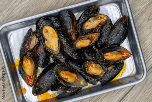 Overhead view of buttery order of mussels served in a pile on a tray