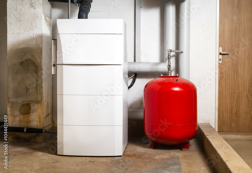 Oil condensing boiler with expansion vessel in boiler room or basement. Oil fired condensing boiler with pump, fan and pressure sensor. Heating system in residential building. Selective focus.