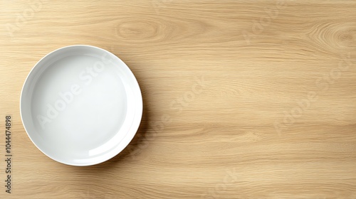 Empty white oval plate on wooden table.