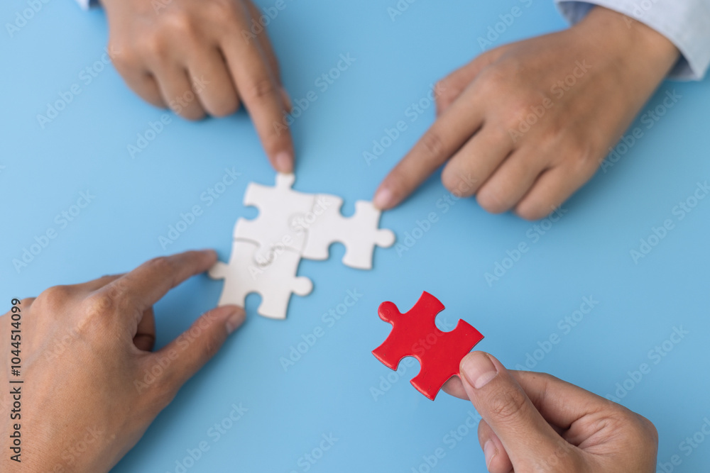 Business team holding parts of jigsaw puzzle trying to find solution to problem together. Concept of challenge and determination as the person works to complete the puzzle. Business team holding parts of jigsaw puzzle trying to find solution to problem together. Concept of challenge and determination as the person works to complete the puzzle.