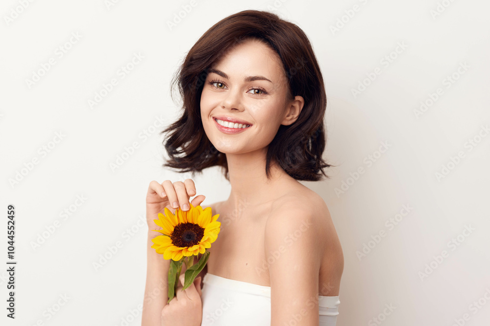 Beautiful young woman holding a sunflower on a white background in stock photo Beautiful young woman holding a sunflower on a white background in stock photo