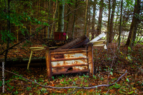 Industrial waste and rubbish black stored in a forest, forbidden dump in a nature, old metal things